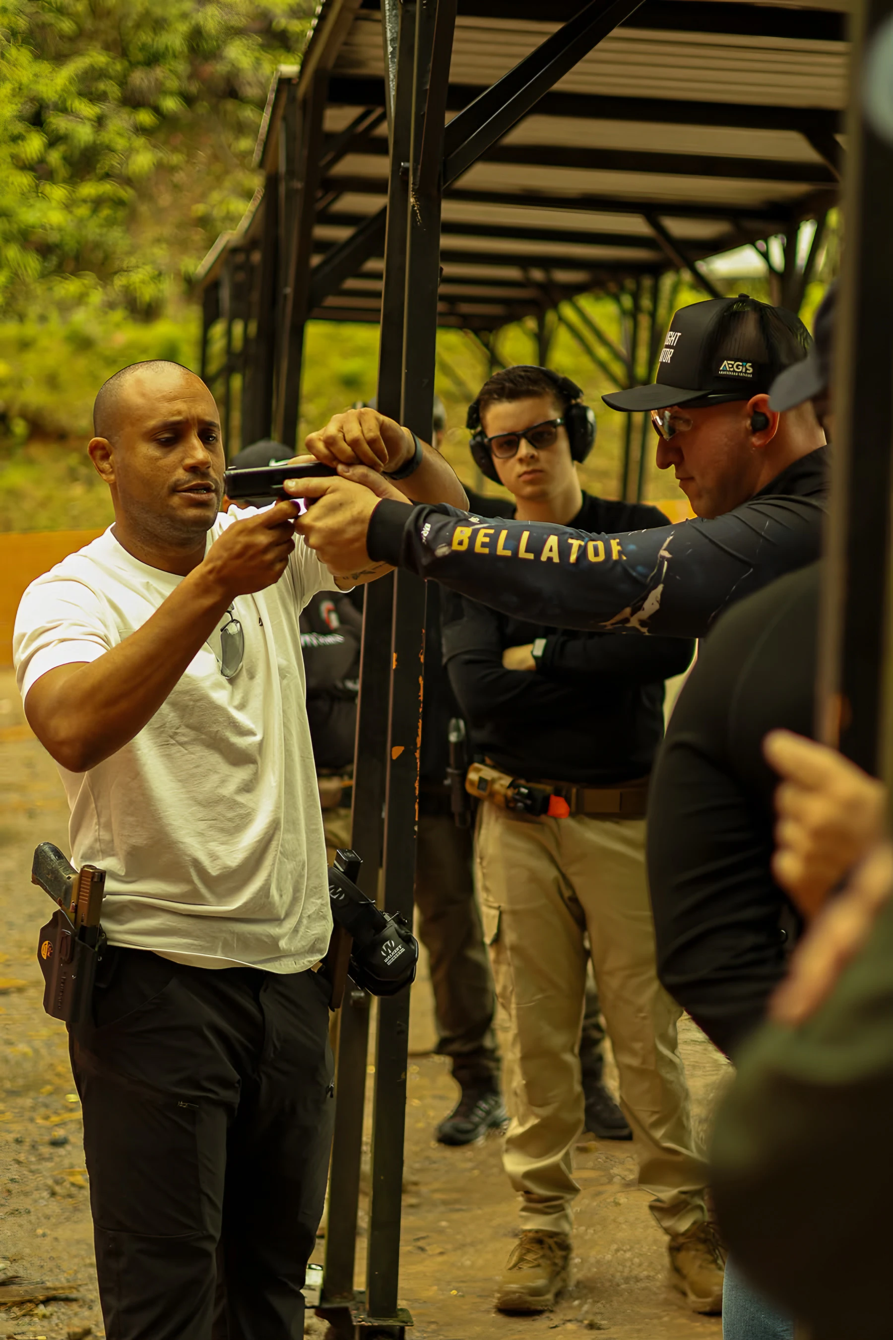 Instrutor Neres ajustando a empunhadura de um aluno na baia de tiro